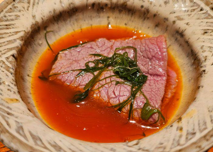 Wagyu beef sukiyaki, soaking in a flavorful broth,